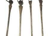 four old metal spoons are lined up on a white surface