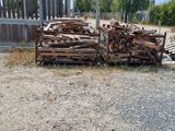 a pile of wood on the ground next to a fence