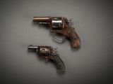 two old revolvers are shown on a gray surface