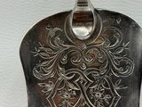 a silver spoon with a floral design on it