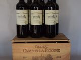 quatre bouteilles de vin rouge dans un coffret en bois posé sur une table
