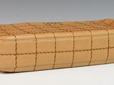 beige leather purse with a woven design on the front