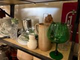 a shelf full of dishes and glasses on a shelf