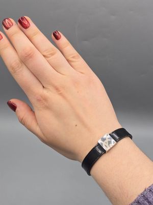 YVES SAINT LAURENT. Bracelet en cuir noir constitué d'un élé…