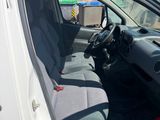 the interior of a white van with the door open and a fire extinguisor in the passenger seat