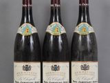 Trois bouteilles de vin sont alignées sur une table en verre