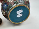 a hand holding a vase that has a tag on it