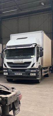 deux camions garés dans un entrepôt, dont l'un se trouve à l'arrière de l'autre
