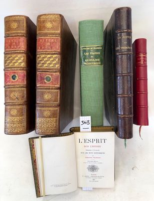 several old books are lined up on a shelf next to each other