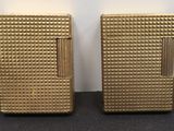 deux briquets dorés posés l'un à côté de l'autre sur une table