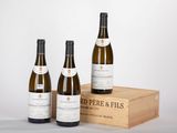 trois bouteilles de vin posées sur une caisse en bois