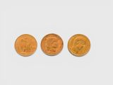 trois types différents de pièces d'or sur une surface blanche