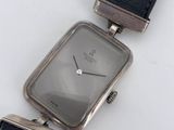 a close up of a watch on a white surface with a black strap