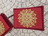 two red boxes with gold designs on them sitting on a stone floor