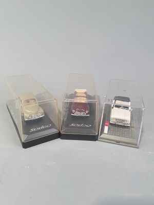 three toy cars in a display case on a table