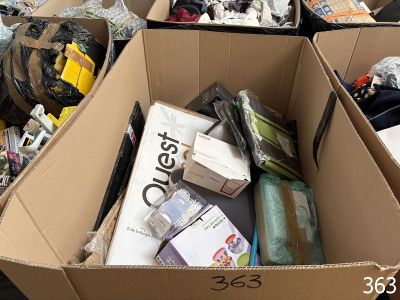 une boîte en carton remplie d'objets hétéroclites sur le sol