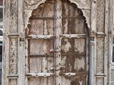 entrée d'un vieux bâtiment avec une porte en bois et une fenêtre