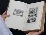 a person holding an open book with pictures on it