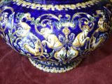 a blue and gold vase sitting on a red cloth