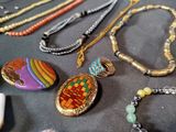 many different necklaces and bracelets on a table