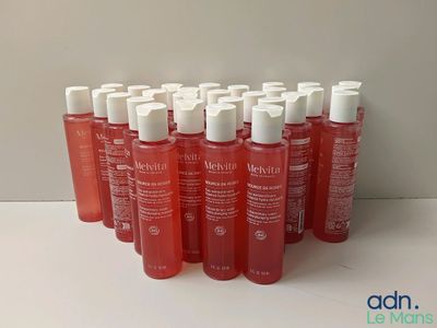 plusieurs bouteilles contenant un liquide rouge posées sur une table blanche