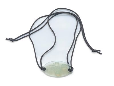 un gros plan d'un collier composé d'une pierre verte montée sur un fil