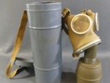 a gas mask sitting next to a metal bucket