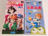 two anime books that are on a white table