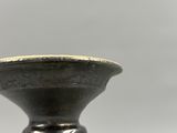 un gros plan d'un vase noir sur lequel figurent des inscriptions