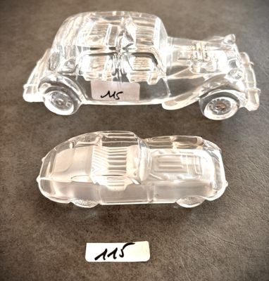 deux petites voitures en plastique transparent posées sur une table