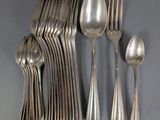 a lot of silver spoons and spoons on the table