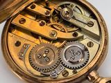 a close up of a pocket watch on a white surface
