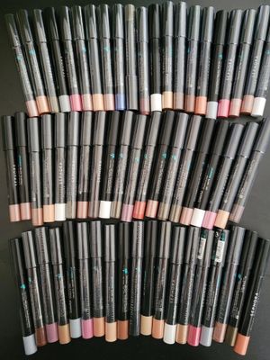 a pile of makeup pencils sitting on top of each other