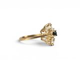 a close up of a gold ring with a black and white diamond