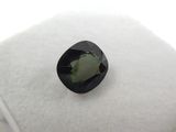a green tourmaline gemstone on a white cushion