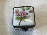 a small white box with a pink flower on it
