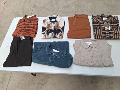 une table sur laquelle sont posés de nombreux vêtements