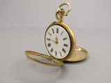 a gold pocket watch with roman numerals on it