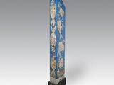 une image représentant une sculpture bleu et or d'un oiseau perché sur une branche