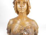 bronze bust of a woman in a dress with flowers on her head