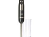 an electric blender with a glass in front of it on a white surface