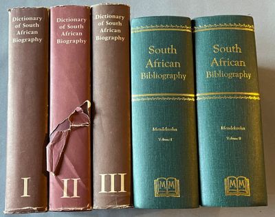 Trois livres sont alignés sur une table, avec un marque-page entre eux.
