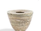 a white and brown vase sitting on a white surface