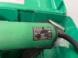 a green trash can with a black hose attached to it