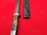 two knives are sitting on a red cloth on a table