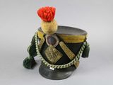 an image of a toy soldier ' s hat with a red pom pom on top of it