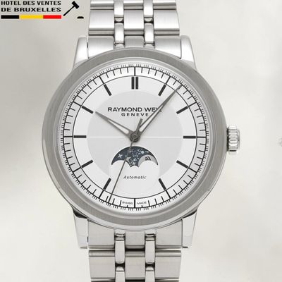 La montre possède un cadran blanc et un bracelet argenté.