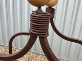 a metal sculpture with two balls on top of it