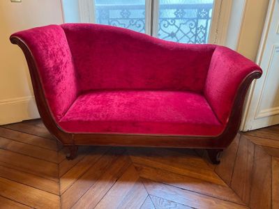 a red couch that is sitting on a wooden floor
