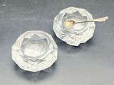 two clear glass bowls with spoons on a table
